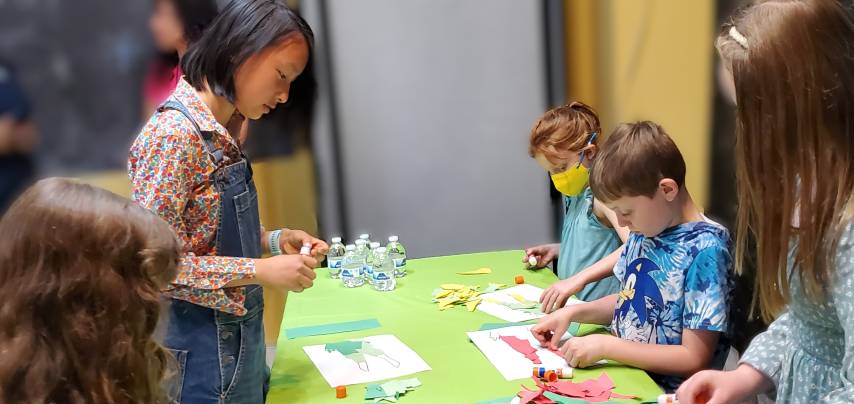 Alex helping children create collages at a hands-on workshop